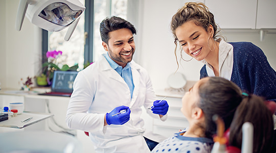 Dentist talking with mother and her daughter