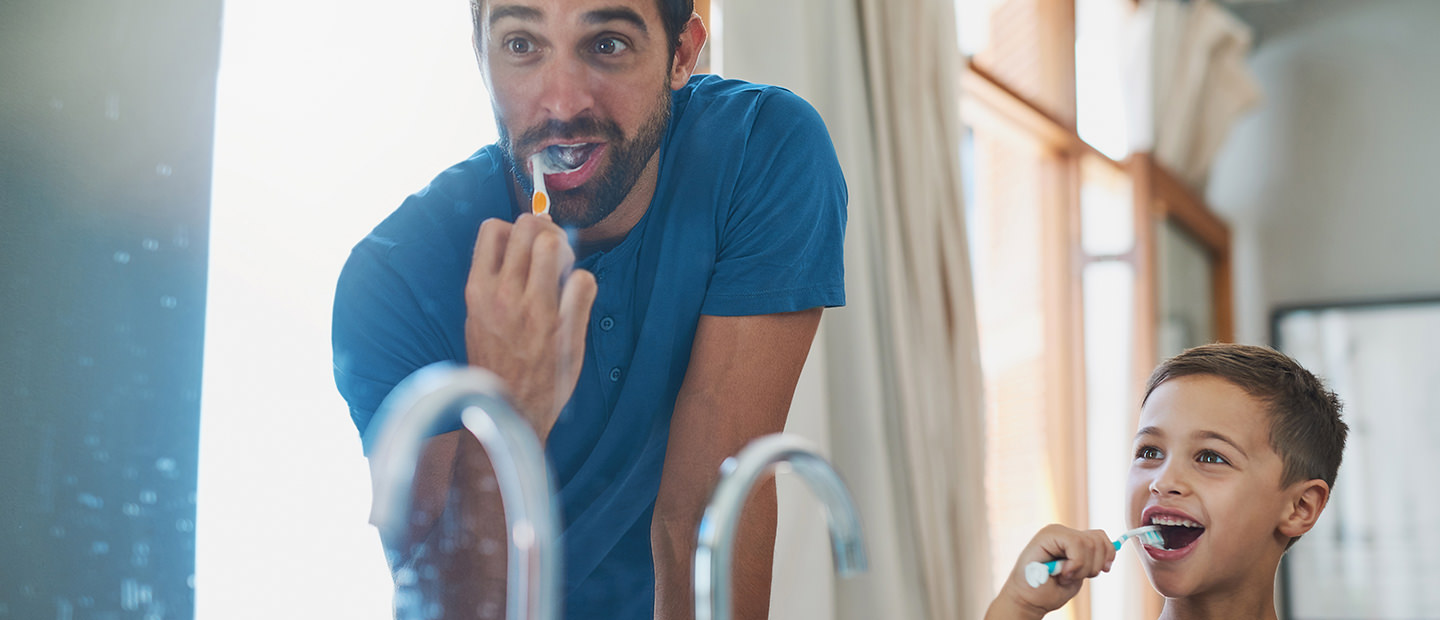 Hombre e hijo cepillarse los dientes