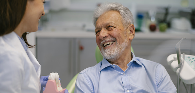 Hombre sonriente hablando con su dentista