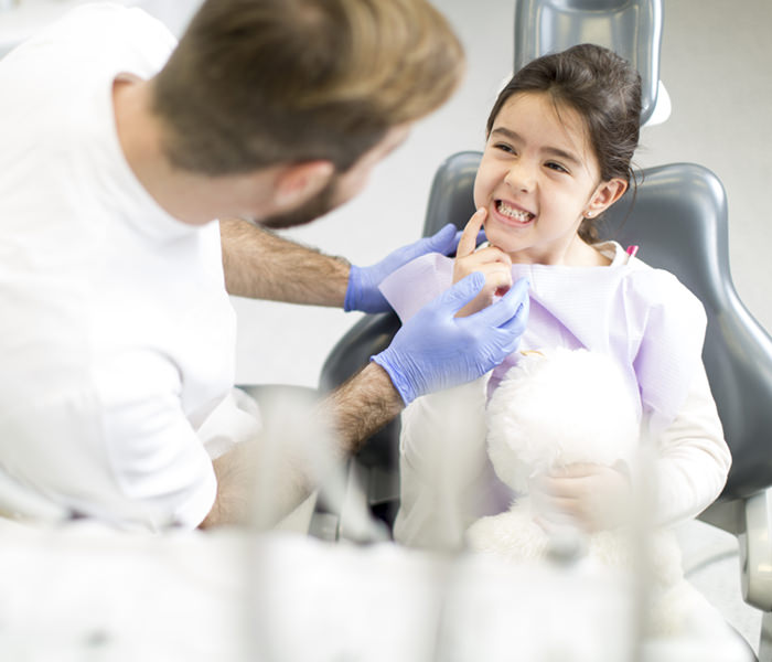 Dentist and girl in dental chair