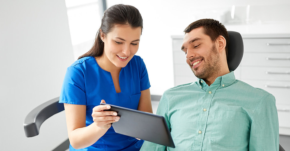 Dentist talking with patient in dental chair