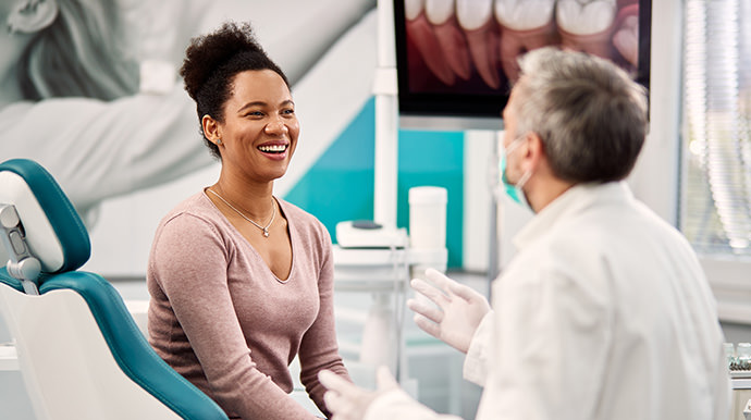 Woman laughing while talking to her dentist