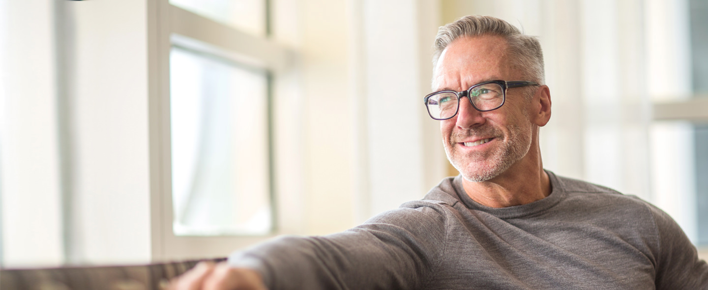 Smiling man sitting by window