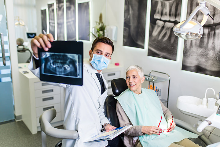 Dentista que muestra al paciente una imagen de rayos X