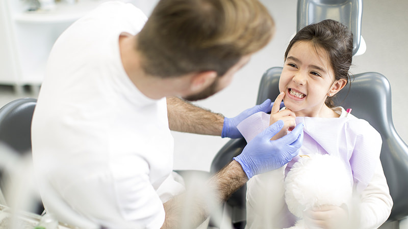 Dentist and a young girl in a dental chair